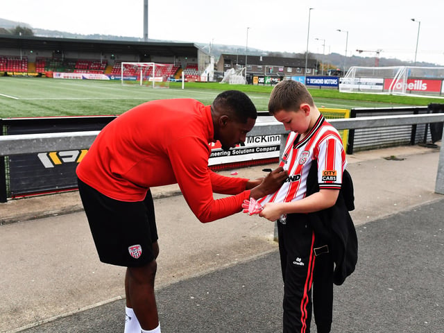 Derry City’s Sadou Diallo signs a shirt for a young fan on Saturday morning prior to the team’s departure for Dublin ahead of Sunday’s FAI Cup Final against Drogheda United. Photograph: George Sweeney.