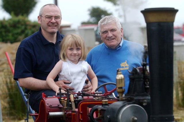 Four-year-old Erin McMenamin, from Inch, with her father, Gary, and grandfather, Maurice, on the half size model steam engine.