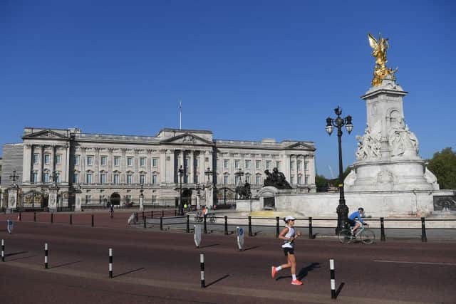 A jogger passes Buckingham Palace; the 40th London Marathon was due to take place this weekend, but has been postponed until October due to coronavirus (Photo: Alex Davidson/Getty Images)