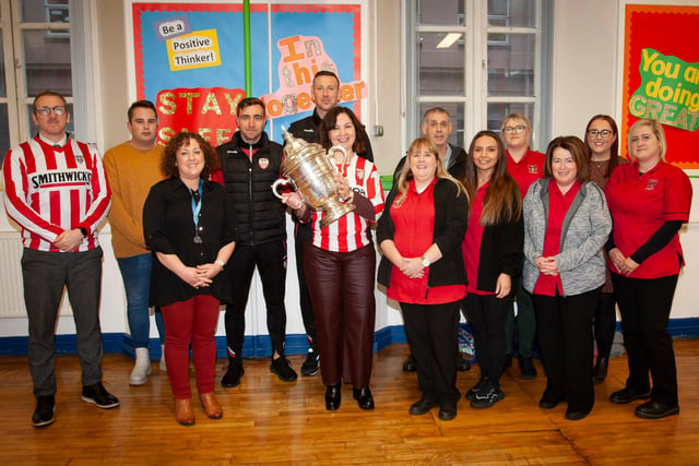 CUP AT ST. EUGENE’S PS. . .  .Mrs. Carol Duffy, Principal, St. Eugene’s PS pictured with the FAI Cup brought to the school by Derry players Joe Thompson and Shane McEleney on Monday morning. Included in photo from left are  Kevin McKenna, Santetiago Torres Lopez, Liam Gallagher, Ciara Barbour, Raychelle Porter, Amanda Carson, Cathy Faulkner, Aisling Carlin, Tara Roddy and Rachel Caldwell.