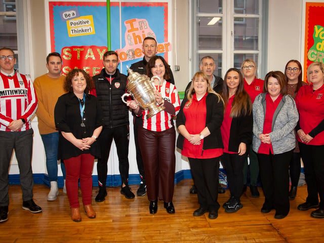 CUP AT ST. EUGENE’S PS. . . .Mrs. Carol Duffy, Principal, St. Eugene’s PS pictured with the FAI Cup brought to the school by Derry players Joe Thompson and Shane McEleney on Monday morning. Included in photo from left are Kevin McKenna, Santetiago Torres Lopez, Liam Gallagher, Ciara Barbour, Raychelle Porter, Amanda Carson, Cathy Faulkner, Aisling Carlin, Tara Roddy and Rachel Caldwell.