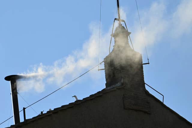 This photograph shows white smoke rising from the chinmey of the Sistine Chapel signaling that cardinals elected a new pope during their conclave in the Vatican on May 8, 2025. (Photo by Alberto PIZZOLI / AFP) (Photo by ALBERTO PIZZOLI/AFP via Getty Images)