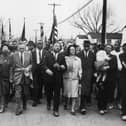 March 1965:  American civil rights campaigner Martin Luther King (1929  - 1968) and his wife Coretta Scott King lead a black voting rights march from Selma, Alabama, to the state capital in Montgomery;  among those pictured are, front row, politician and civil rights activist John Lewis (1940 – 2020), Reverend Ralph Abernathy (1926 - 1990), Ruth Harris Bunche (1906 - 1988), Nobel Prize-winning political scientist and diplomat Ralph Bunche (1904 - 1971), activist Hosea Williams (1926 – 2000 right carrying child). (Photo by William Lovelace/Daily Express/Hulton Archive/Getty Images)