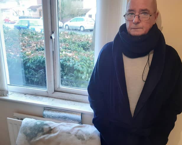 Martin Wade beside a pillow destroyed by damp. He can no longer use his bedroom.