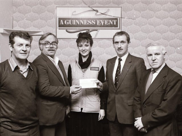 Guinness representatives presenting a cheque to sponsor the Vintners League.