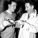 ‘I know how you feel', says Charlie Heffron - Derry City's goalkeeper when the ‘Candy Stripes' won the cup in 1954 - to city's young netminder, Eddie Mahon, as Eddie shows Charlie his cup winners' medal in the dressing room of Windsor Park.
