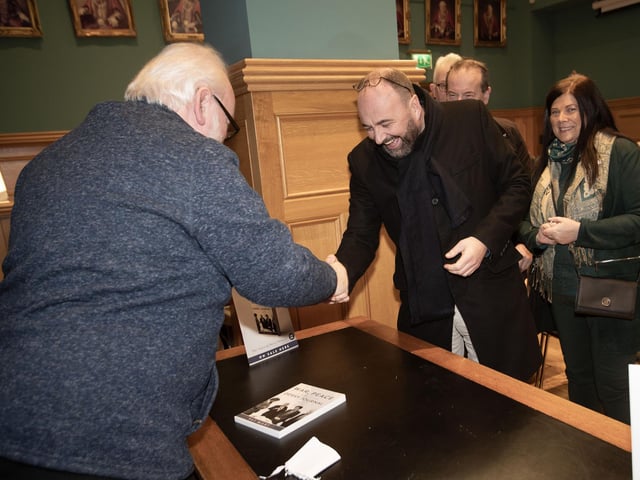 AUTHOR TO AUTHOR. . . .Pat congratulates Derry poet and school principal Feargal Friel before signing a copy of his new book 'War, Peace and the Derry Journal'.