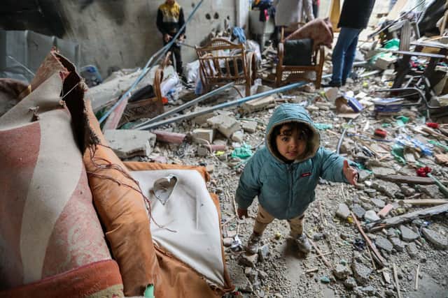 RAFAH, GAZA - MARCH 19 : A young child is seen as people inspect damage and recover items from their homes following Israeli air strikes on March 19, 2024 in Rafah, Gaza. Despite warnings from US President Biden, Israeli forces have targeted the city of Rafah which is currently home to an estimated million Palestinian refugees. According to Gaza's Ministry of Health, 31,553 Palestinians have been killed, and 73,546 wounded in Israel's ongoing bombardment of Gaza starting on October 7.(Photo by Ahmad Hasaballah/Getty Images)