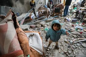 RAFAH, GAZA - MARCH 19 : A young child is seen as people inspect damage and recover items from their homes following Israeli air strikes on March 19, 2024 in Rafah, Gaza. Despite warnings from US President Biden, Israeli forces have targeted the city of Rafah which is currently home to an estimated million Palestinian refugees. According to Gaza's Ministry of Health, 31,553 Palestinians have been killed, and 73,546 wounded in Israel's ongoing bombardment of Gaza starting on October 7.(Photo by Ahmad Hasaballah/Getty Images)