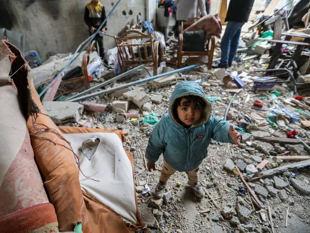 RAFAH, GAZA - MARCH 19 : A young child is seen as people inspect damage and recover items from their homes following Israeli air strikes on March 19, 2024 in Rafah, Gaza. Despite warnings from US President Biden, Israeli forces have targeted the city of Rafah which is currently home to an estimated million Palestinian refugees. According to Gaza's Ministry of Health, 31,553 Palestinians have been killed, and 73,546 wounded in Israel's ongoing bombardment of Gaza starting on October 7.(Photo by Ahmad Hasaballah/Getty Images)