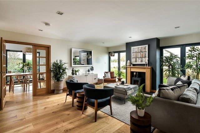 The family room has doors leading out into the garden, and a log burning stove with modern wooden mantlepiece.