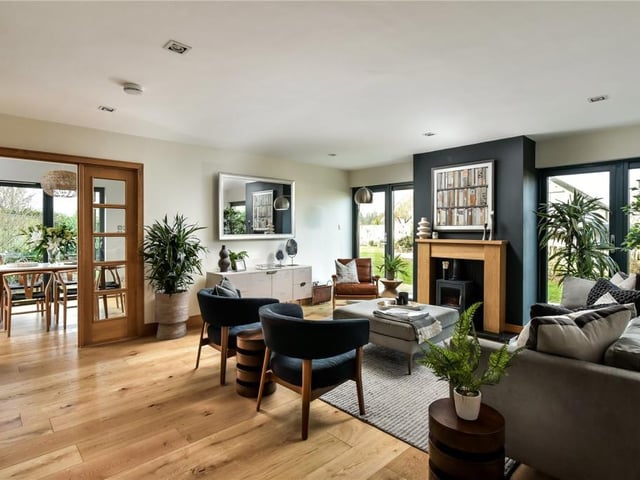 The family room has doors leading out into the garden, and a log burning stove with modern wooden mantlepiece.