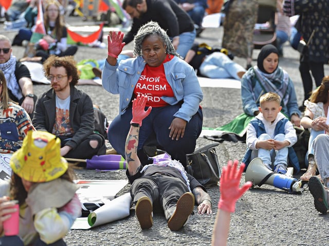 People taking part in a Freedom for Palestine march and rally “lay dead” on Shipquay Street, on Saturday afternoon, highlighting the number of Palestinians who have been killed by Israel. Photo: George Sweeney