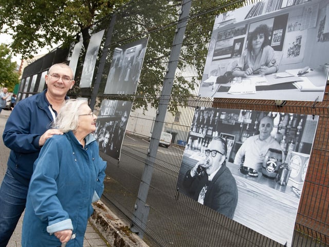 Well known community activist Mary Nelis and her son Declan looking at a photo of her in Friday's exhibition at Pilot's Row.