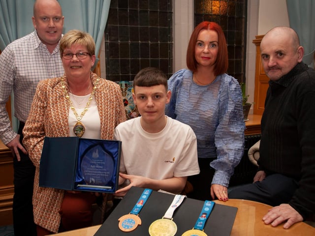 WELL DONE KYLE!. . . .The Deputy Mayor of Derry City and Strabane District Council, Angela Dobbins making a special presentation to Derry teenager Kyle Moore in recognition of his recent success in the WAKO World Championships in Italy and his gold medal success at the Bristol Open, during a reception in his honour at the Mayor’s Parlour, Guildhall on Thursday night last. Included are Kyle’s parents Paul and Shauna and his coach Gary Kelly.