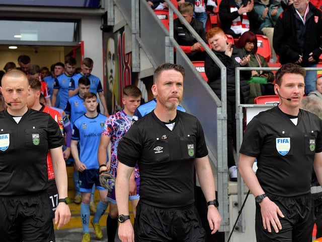 Match referee Eoghan O’Shea leads the Derry City and UCD teams onto the pitch on Friday evening last. Photo: George Sweeney.  DER2320GS – 135