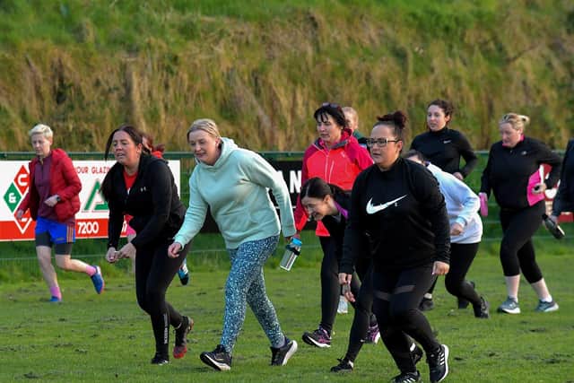 Warm-up exercises ahead of Doire Trasna’s first Mothers and Others football practice session, at Corrody Road. Photo: George Sweeney. DER2316GS – 10