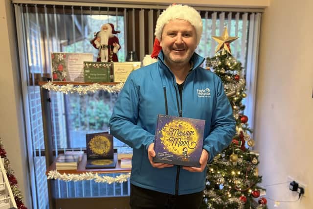 A very festive Donall Henderson, Chief Executive of the Foyle Hospice, with the book 'A Message in the Moon,' which can be bought at the hospice.