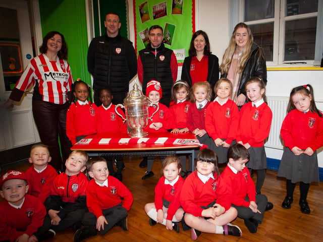 P1 pupils at St. Eugene’s PS show their support for Derry City on Monday last as players Shane McEleney and Joe Thompson brought the FAI Cup to the school.