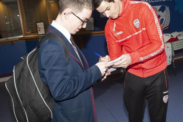 Oakgrove student Leo Arbuckle gets an autograph from Derry City player Ciaran Coll.
