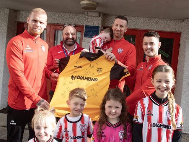Mr Feargal Friel being presented with the jersey by the Derry City players and their children; Roan, Ora, Sophia, Rossa and Cadhla on Tuesday. (Photos: Jim McCafferty Photography)