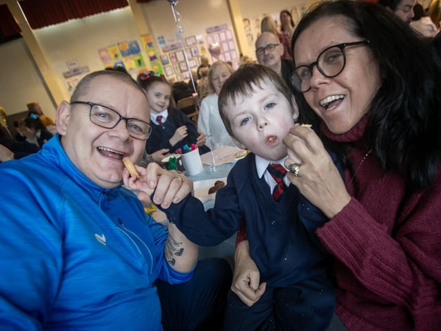 One of the younger pupils at Holy Child sharing his biscuits with granda and granny on Wednesday. : .