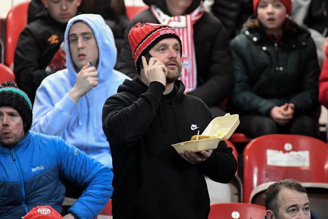 Multi-tasking at the Brandywell. This Derry City fan enjoying his chips and chatting on the phone at the Presidents Cup final at Brandywell on Friday evening. Photo: George Sweeney. DER2307GS – 78