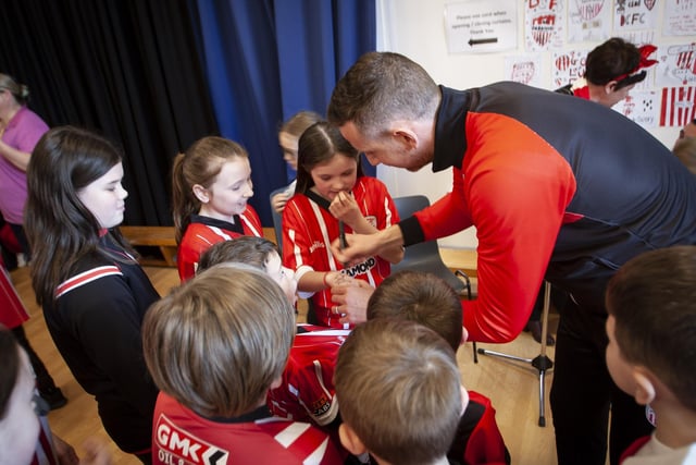 Derry City player Shane McEleney signs autographs for pupils during his visit to Steelstown Primary School on Tuesday. (Photo: Jim McCafferty)