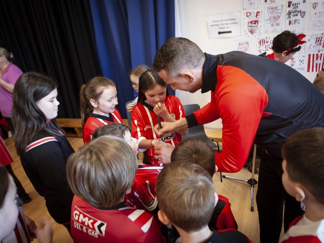 Derry City player Shane McEleney signs autographs for pupils during his visit to Steelstown Primary School on Tuesday. (Photo: Jim McCafferty)