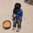 A Palestinian boy has a bite from a ration of hot food from a charity kitchen set up at the Islamic University campus in Gaza City on May 12, 2025. Israeli Prime Minister Benjamin Netanyahu said on May 12 that the release of a US-Israeli hostage announced by Hamas would not lead to a ceasefire in the Gaza Strip or the release of Palestinian detainees. (Photo by Omar AL-QATTAA / AFP) (Photo by OMAR AL-QATTAA/AFP via Getty Images)