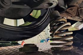The modified suspension of one vehicle fell off when it was placed on an inspection ramp.