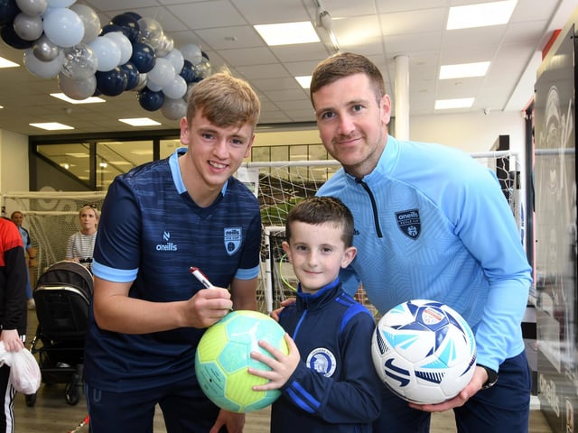 Derry City stars Patrick McEleney and Ciaron Harkin autographing a ball for one of the youngsters who enjoyed meeting them at the O'Neills Superstore on Tuesday.