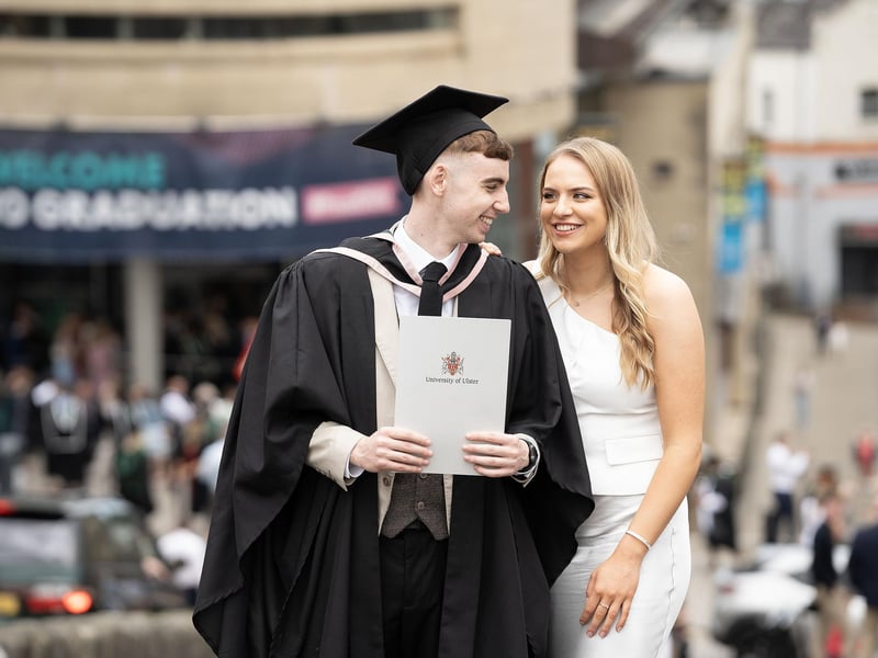 Engineering graduate James Gallen from Strabane celebrates with girlfriend Ciara Kelly as he graduates from Ulster University in Derry on Monday July 8.  (Photo: Nigel McDowell / Ulster University)