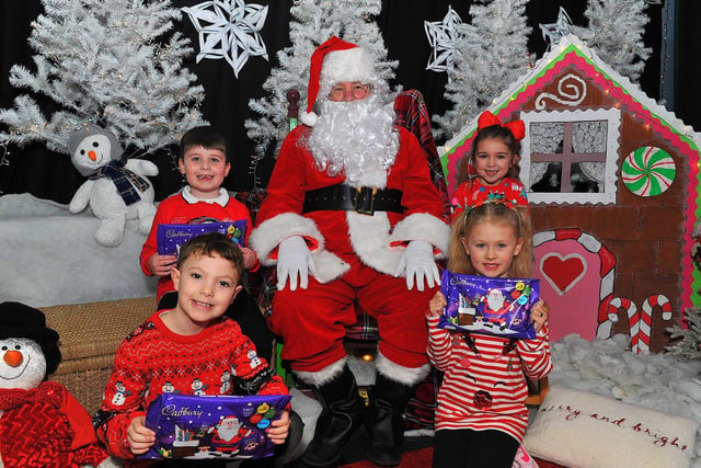 St Eithne’s Primary School P3 pupils Luke, Rogan, Esla and Laura from Miss Gallagher’s class pictured with Santa during his on Friday. Photo: George Sweeney. DER2250GS – 47