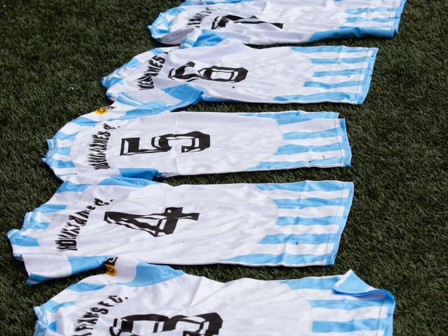 Football jerseys are laid on the pitch as players ready themselves for the match.