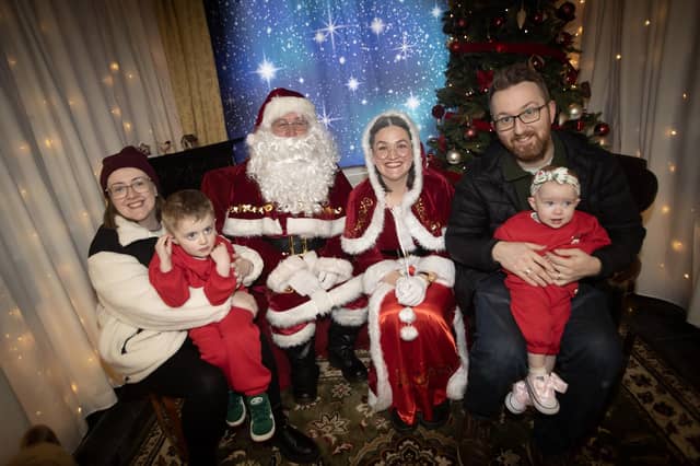 One of the many families getting a photo and collecting a present from Santa on Saturday at Derry Credit Union. : .