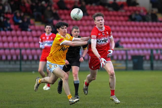 Antrim’s Paul Duffin and Derry’s Sean Young contest a loose ball. Photo: George Sweeney