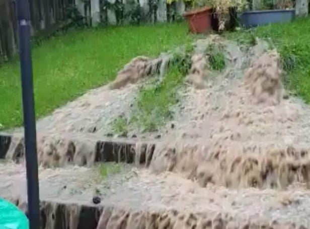 Sewage and rainwater cascading from a broken sewage pipe in a Derry garden.
