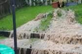 Sewage and rainwater cascading from a broken sewage pipe in a Derry garden.