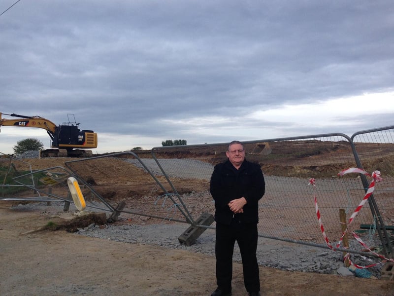 Sinn Fein Councillor Tony Hassan next to the building site. 