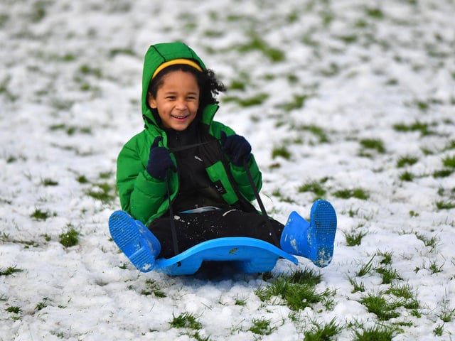 Children enjoy a day off school and a slide in the snow in Brooke Park on Thursday afternoon. Photo: George Sweeney