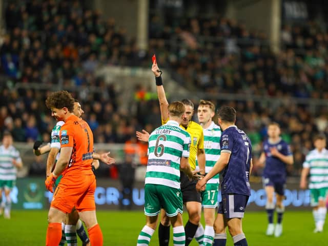 Referee Paul McLaughlin brandishes the first of two red cards on the night to Ed McGinty after the Rovers keeper handled outside his penalty area to deny Danny Mullen a chance.