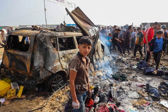Palestinians gather at the site of an Israeli strike on a camp area housing internally displaced people in Rafah on May 27, 2024, amid ongoing battles between Israel and the Palestinian Hamas militant group. Hamas and the Palestinian Authority said Israeli strikes on a centre for displaced people killed dozens near the southern city of Rafah on May 26, while the Israeli army said it had targeted Hamas militants. (Photo by Eyad BABA / AFP) (Photo by EYAD BABA/AFP via Getty Images)