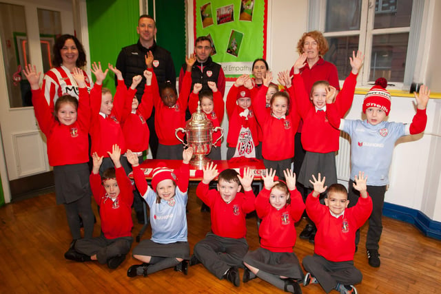 P3 pupils at St. Eugene’s PS show their support for Derry City on Monday last as players Shane McEleney and Joe Thompson brought the FAI Cup to the school.