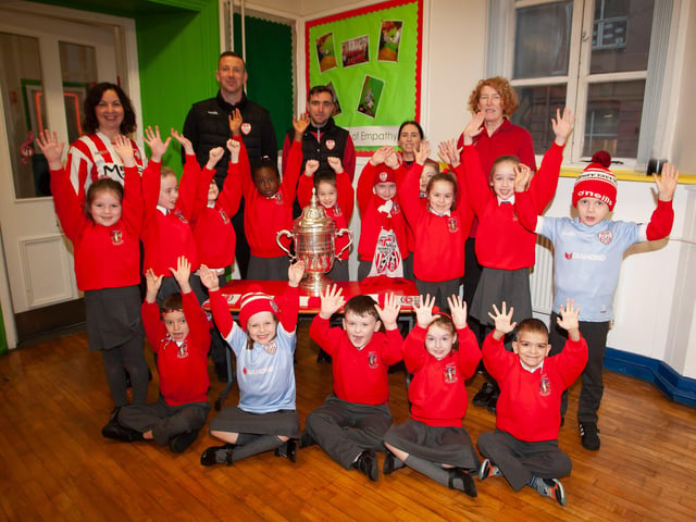 P3 pupils at St. Eugene’s PS show their support for Derry City on Monday last as players Shane McEleney and Joe Thompson brought the FAI Cup to the school.
