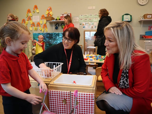 First Minister Michelle O’Neill hunkers down to chat to a little girl alongside Louise Kearney from Action for Children.