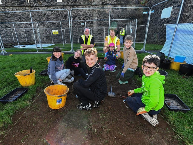 Gaelscoil Eadain Mhoir pupils pictured with archaeologist Conall O’Neill and Site director Ruairí " Baoill at the Queen’s University Centre for Community Archaeology dig in an area beneath the City Walls. Photo: George Sweeney