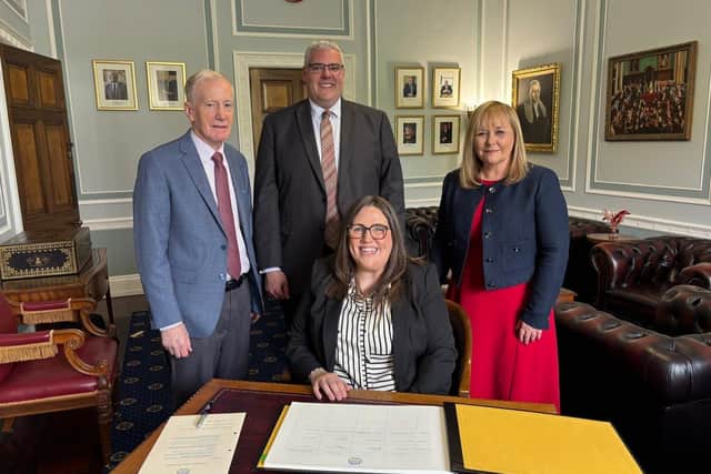 New Foyle MLA Julie Middleton signs the Stormont roll of membership as DUP leader Gavin Robinson, East Derry MP Gregory Campbell and Strangford MLA Michelle McIlveen look on.