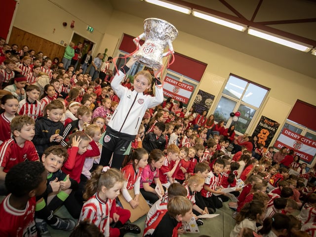 UP WITH THE CUP!. . . Hollybush PS pupil Mia shows her support for Derry City on Friday. (Photos: Jim McCafferty Photography)