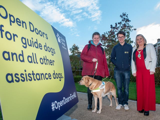The Mayor Councillor Sandra Duffy pictured with Andrea O’Hagan and her Guide Dog Becky and Mark Quinn, Guide Dogs Marketing Manager as she helped promote Guide Dog Awareness and encourage people to open doors for assistance dogs. Picture Martin McKeown. 14.11.22